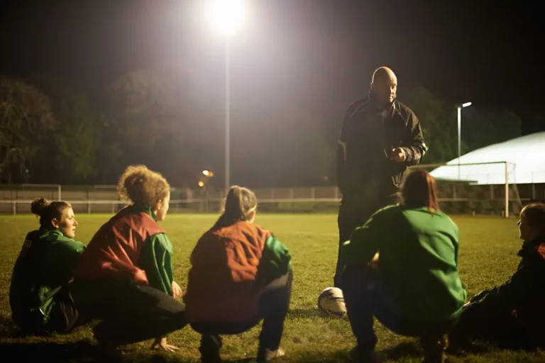 Coach briefing players on the field, the daily reinforcement that turns sales training into habits