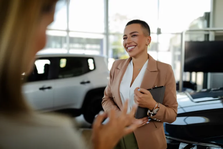 Car salesperson listening to customers in a dealership showroom