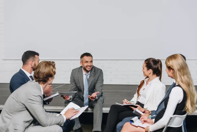 Dealership leader coaching a sales team, setting the tone with a positive attitude