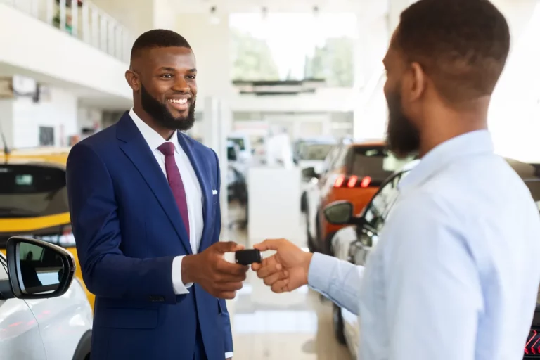 Dealer handing keys to a satisfied buyer at delivery, the moment that drives CSI scores