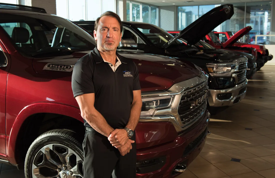 David Lowe on the showroom floor beside a row of trucks